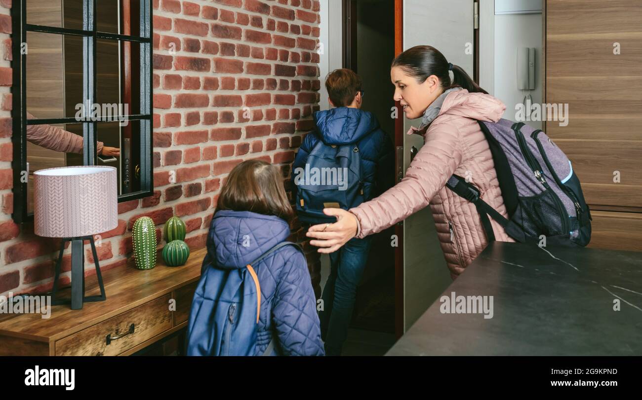 Family with emergency backpacks leaving their front door quickly Stock Photo