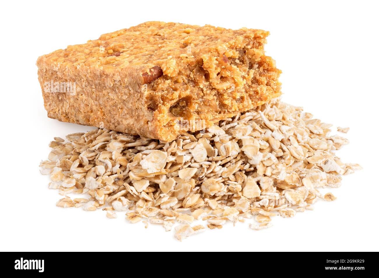 Partially eaten oat flapjack with nuts on a pile of oats isolated on white. Stock Photo