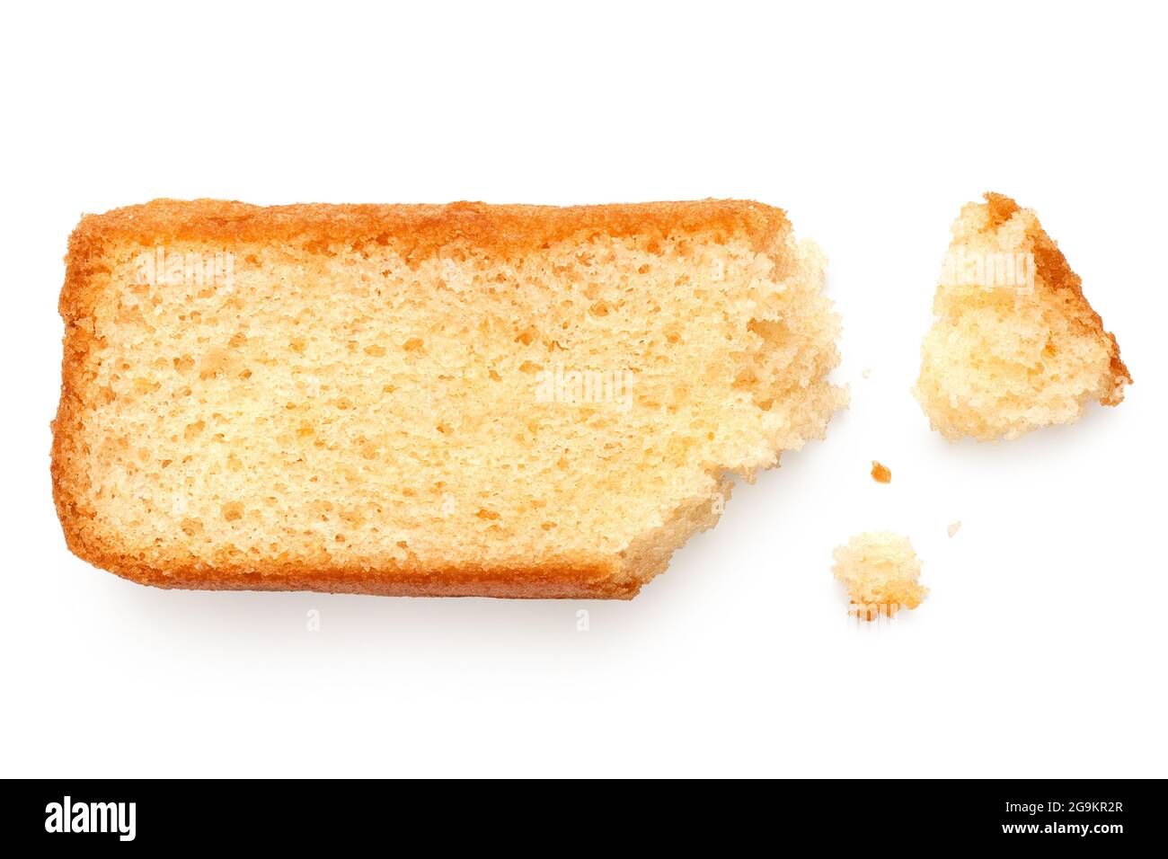 Partially eaten slice of plain sponge cake lying flat isolated on white. With crumbs. Top view. Stock Photo