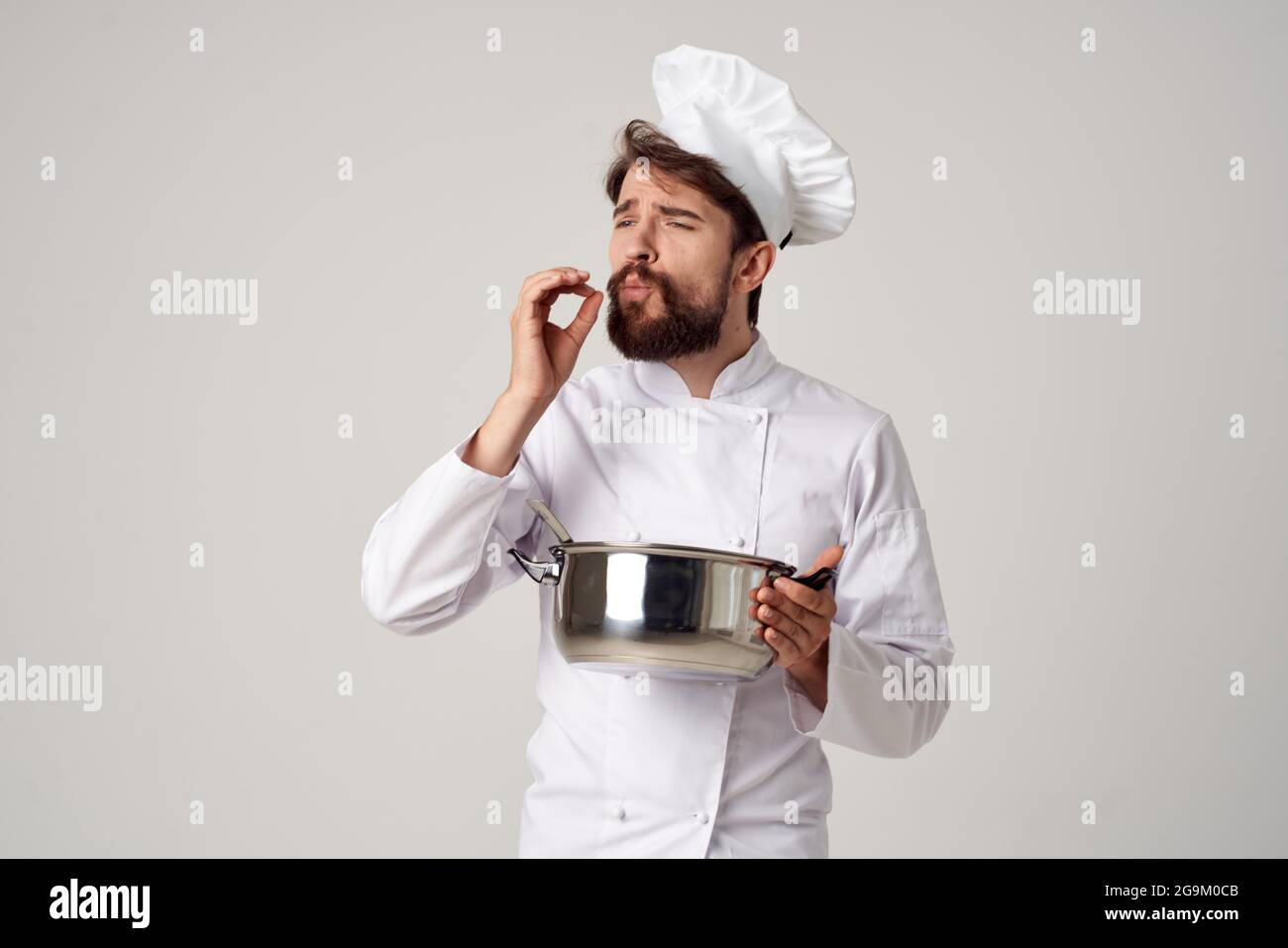 professional chef with a saucepan in his hands trying food cooking work ...