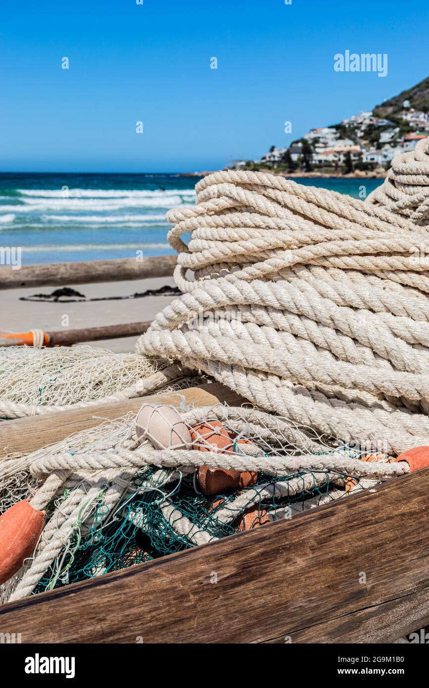 Beachy Net Rope traditional fishing net and rope on small rowing boat on beach Stock ...