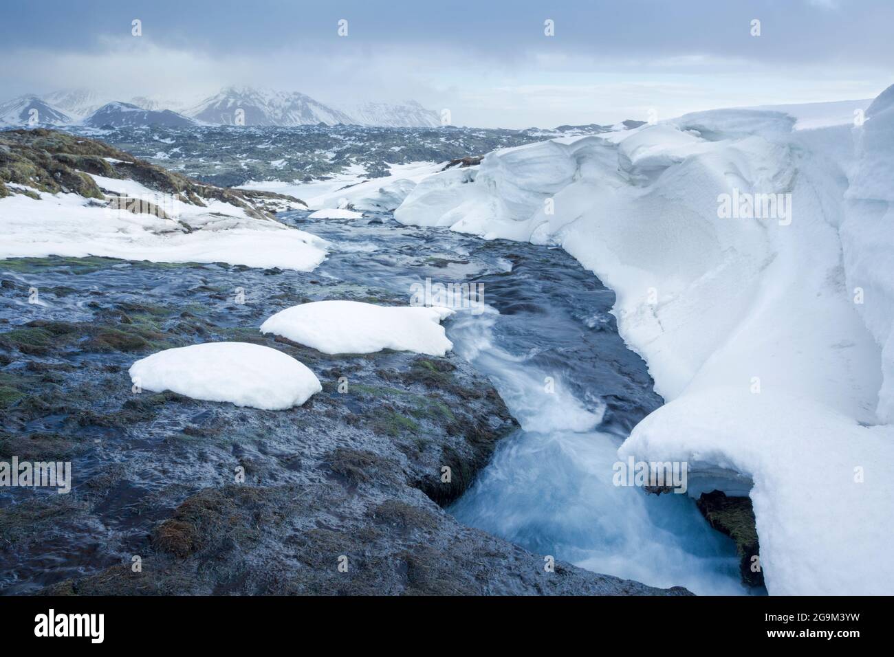 A glacial river cuts its way through snow and ice on the Snaefellsnes Penninsular in west Iceland Stock Photo