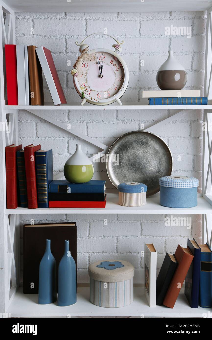 Bookshelves with books and decorative objects on brick wall background ...