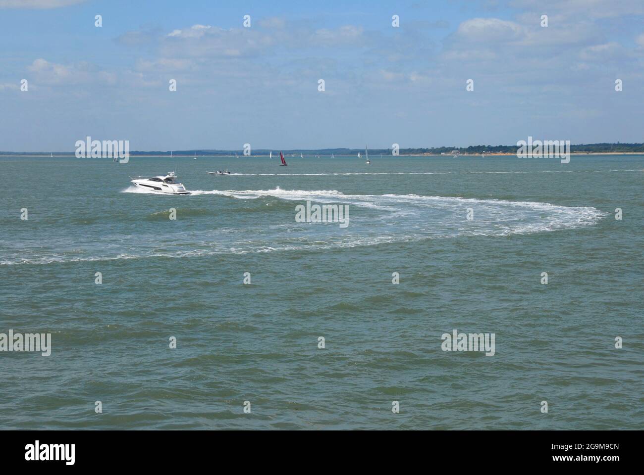 Motor boat making wide circular turn on the Solent during Cowes Week regatta Stock Photo