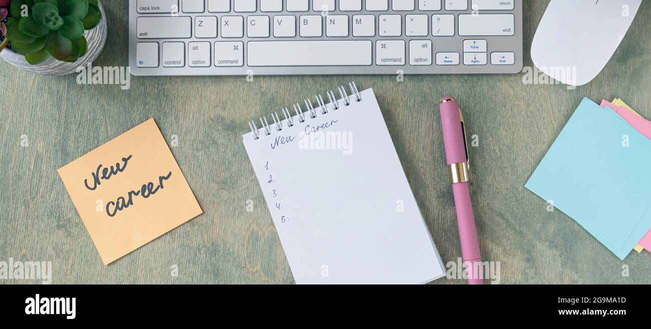 banner with top view of the desktop with note with words NEW CAREER, empty notepad, pen, keyboard, cactus and mause on a wooden table. Business and fi Stock Photo