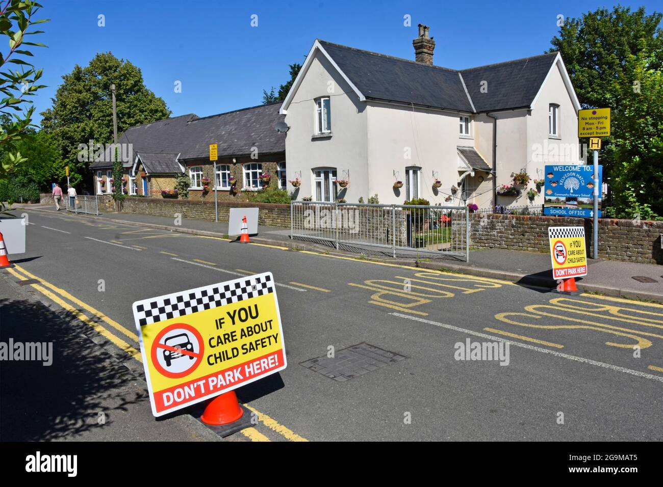 Village street parking restrictions outside primary school gate are not enough extra child road safety signs in use at Kelvedon Hatch Essex England UK Stock Photo