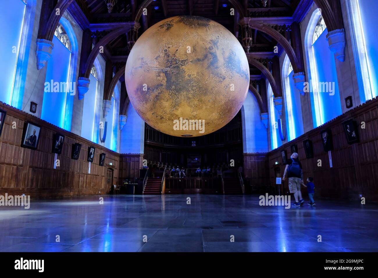 Bristol, UK. 27th July, 2021. Luke Jerram shows his seven-metre model of Mars in the Great Hall of the Wills Memorial Building Bristol University. Using NASA imagery, the model allows people to see the mountains, valleys and craters of our neighbour the Red Planet. The exhibition will be open to the public, staff and students from 27th July to 1st August. Credit: JMF News/Alamy Live News Stock Photo