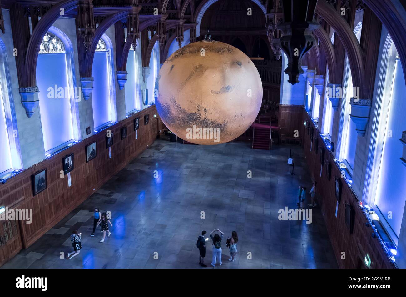 Bristol, UK. 27th July, 2021. Luke Jerram shows his seven-metre model of Mars in the Great Hall of the Wills Memorial Building Bristol University. Using NASA imagery, the model allows people to see the mountains, valleys and craters of our neighbour the Red Planet. The exhibition will be open to the public, staff and students from 27th July to 1st August. Credit: JMF News/Alamy Live News Stock Photo