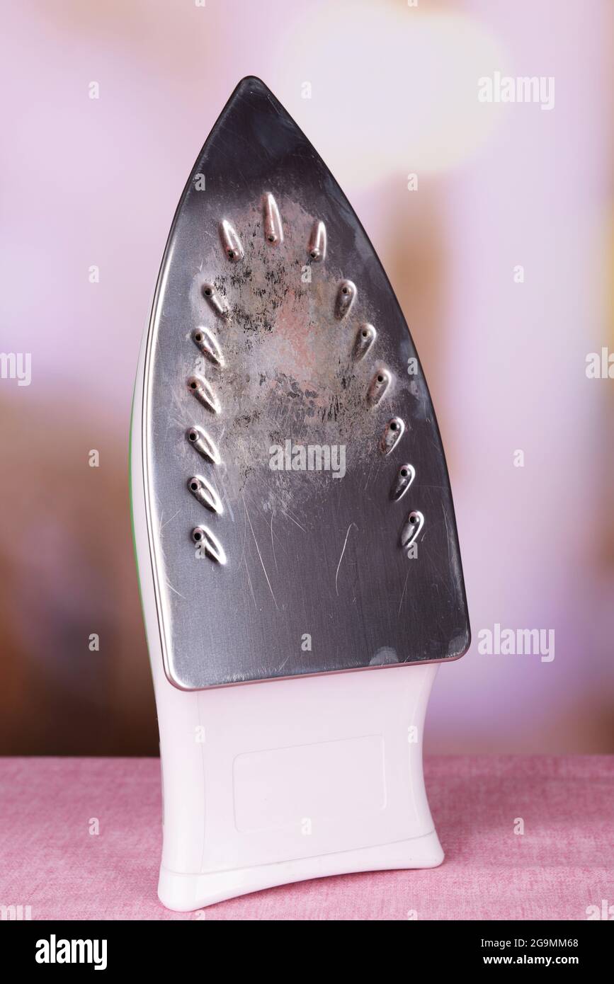 Flat iron with burnt mark on table on bright background Stock Photo Alamy