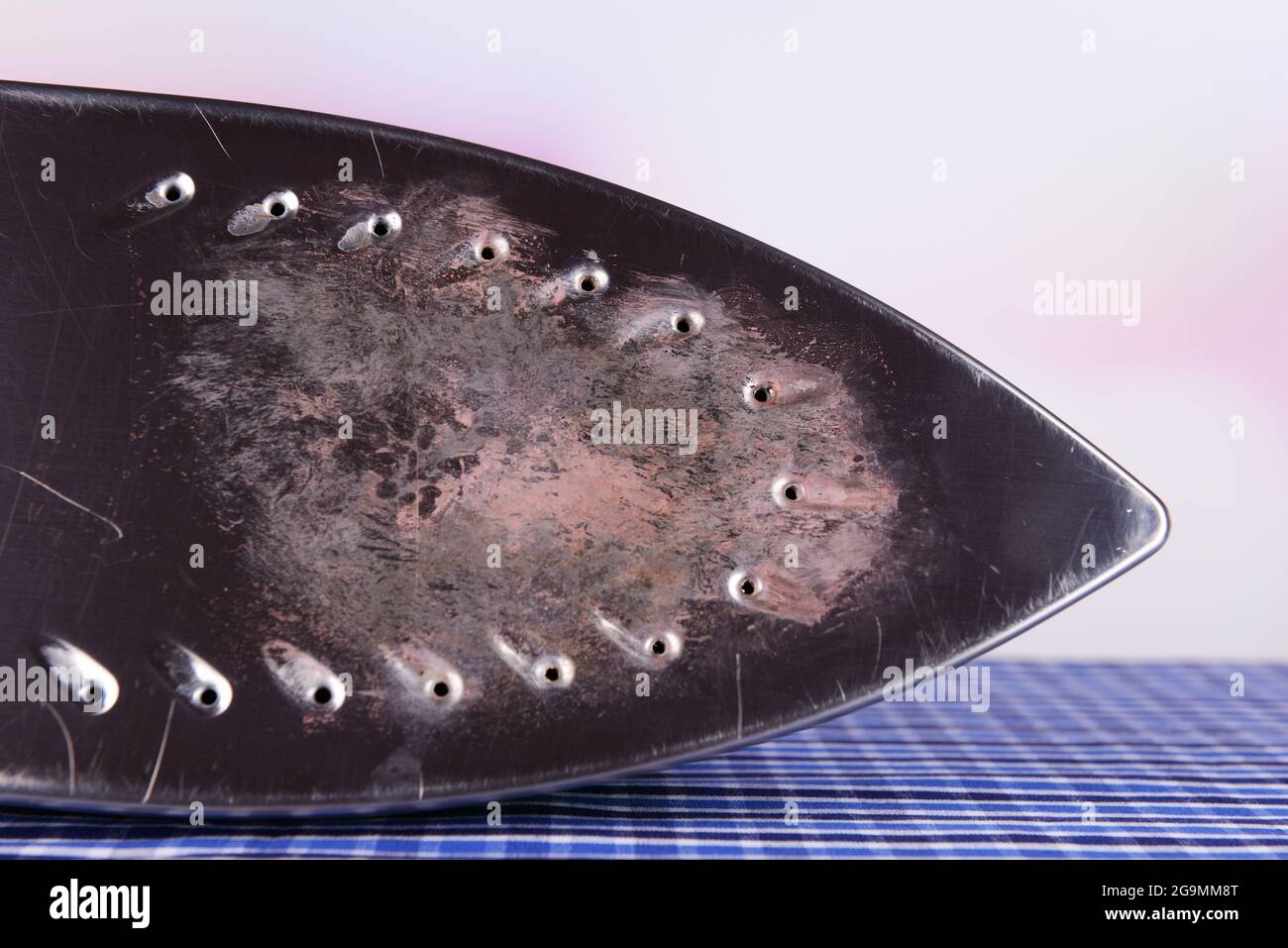 Flat iron with burnt mark on table on bright background Stock Photo Alamy