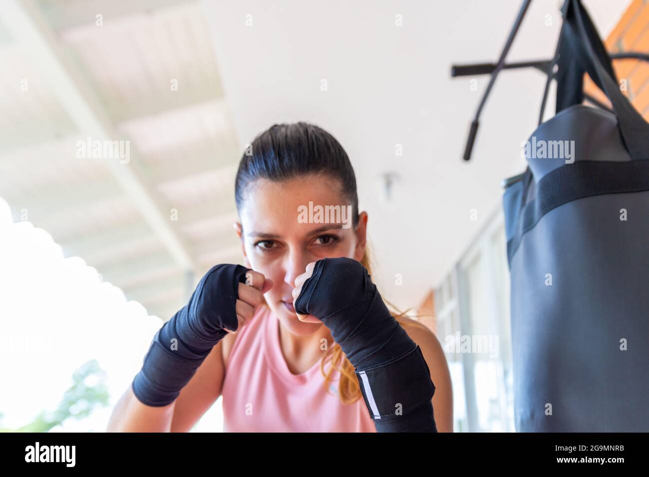 Strong Woman in Combat Pose Looking at Camera Stock Photo