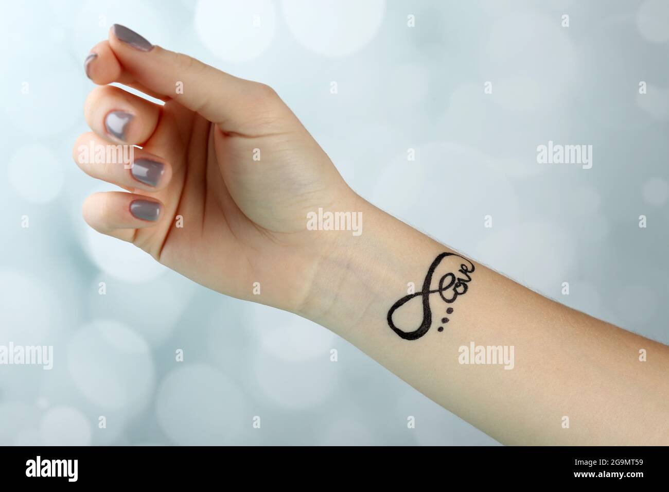 Female Arm With Tattoo On Light Background Stock Photo Alamy