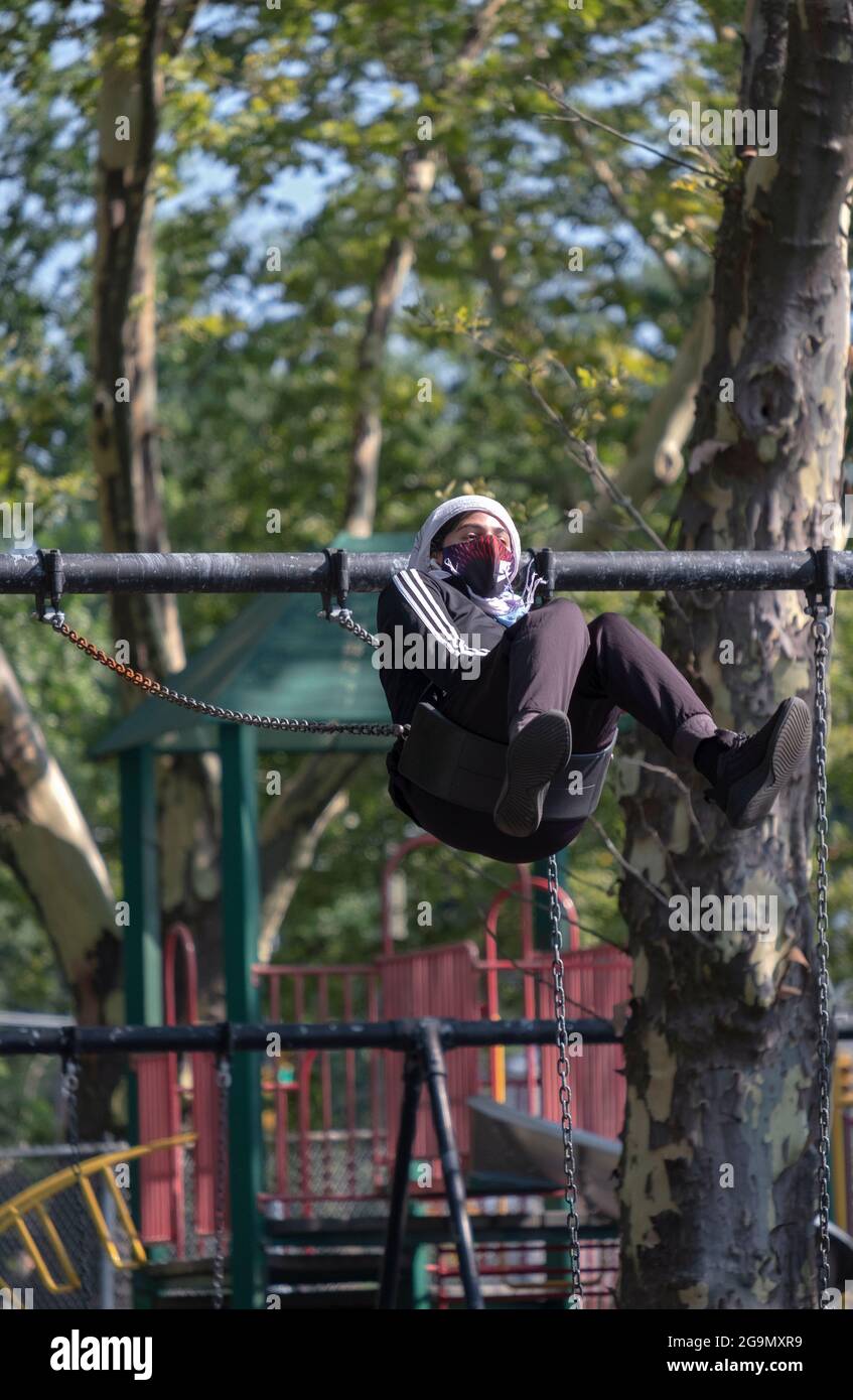 A person on a swing flying high. In Flushing, Queens, New York. Stock Photo