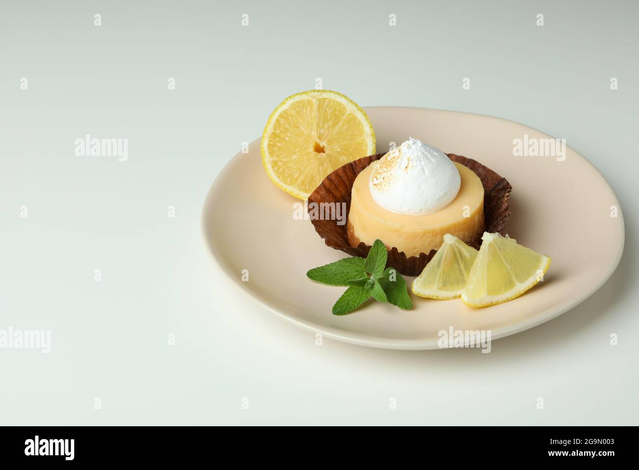 Plate with lemon cupcake on white background Stock Photo