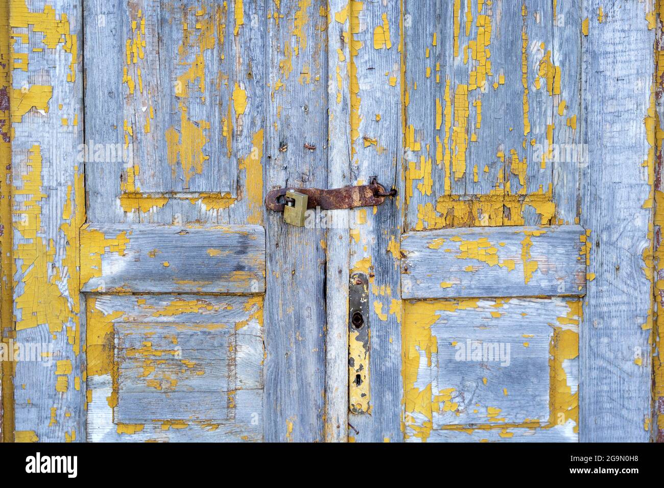 Old wooden door with peeled off yellow paint Stock Photo