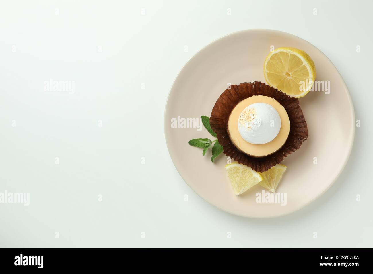 Plate with lemon cupcake on white background Stock Photo