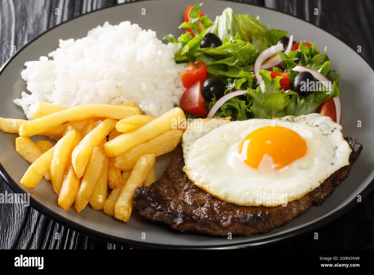 Beef Steak with Egg, french fries, rice and salad closeup in the plate on the table. Horizontal Stock Photo