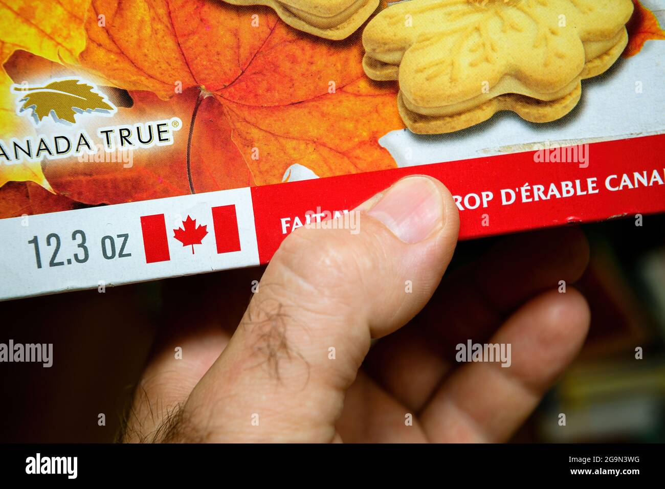 holding package with Canada True iconic biscuits with maple syrup Stock
