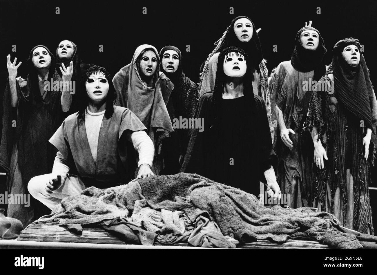 'Choephori' - front centre: Orestes and Electra  with Chorus of Trojan Women in THE ORESTEIA  by Aeschylus at the Olivier Theatre, National Theatre (NT), London SE1  28/11/1981  in a version by Tony Harrison  design: Jocelyn Herbert assisted by Sue Jenkinson  lighting: John Bury  movement: Stuart Hopps  director: Peter Hall Stock Photo
