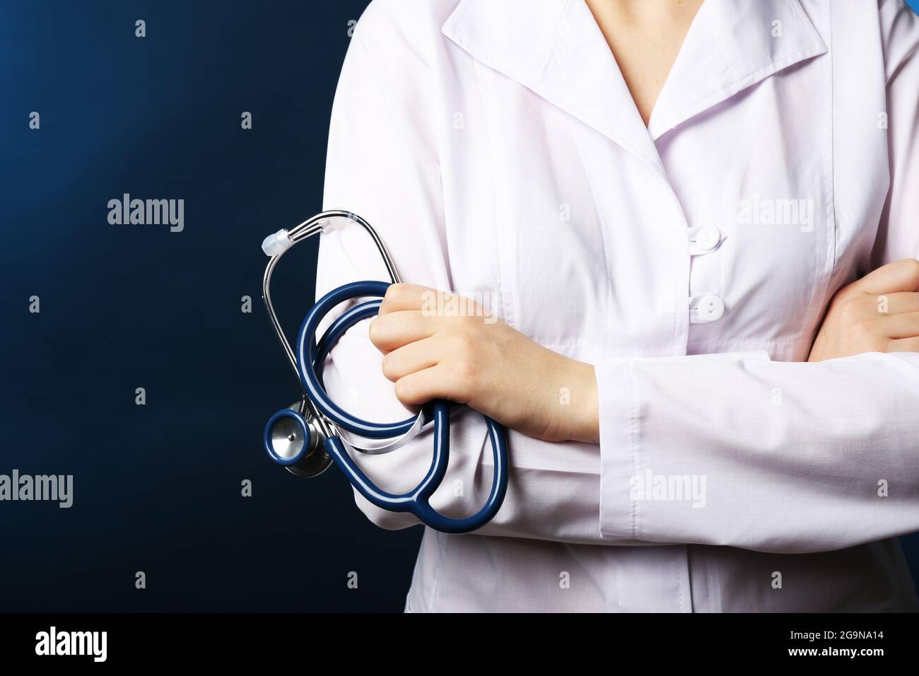 https://c8.alamy.com/comp/2G9NA14/close-up-of-doctor-hand-with-stethoscope-on-dark-blue-background-2G9NA14.jpg