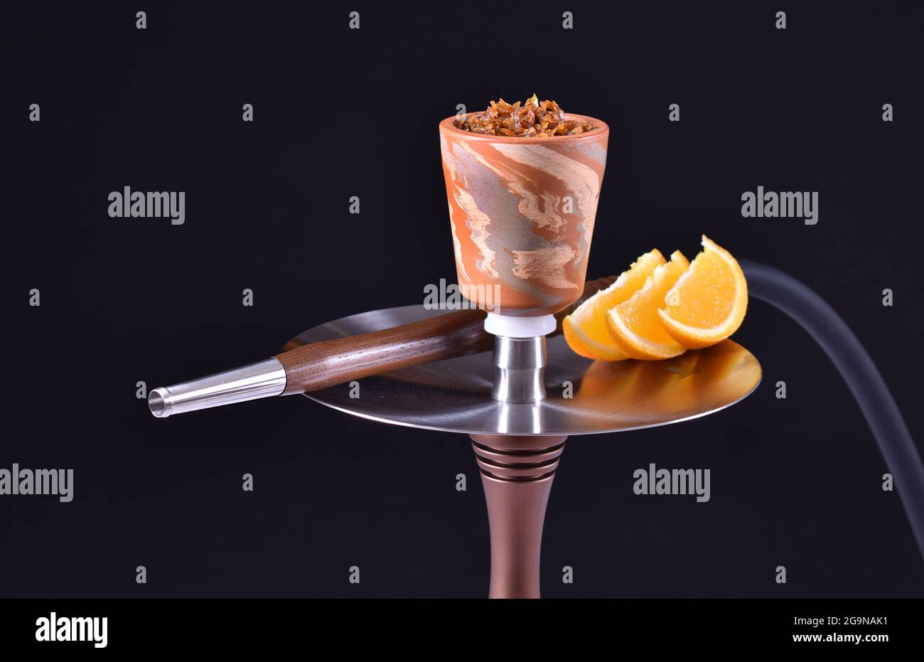 hookah bowl with tobacco on an black background with orange Stock Photo