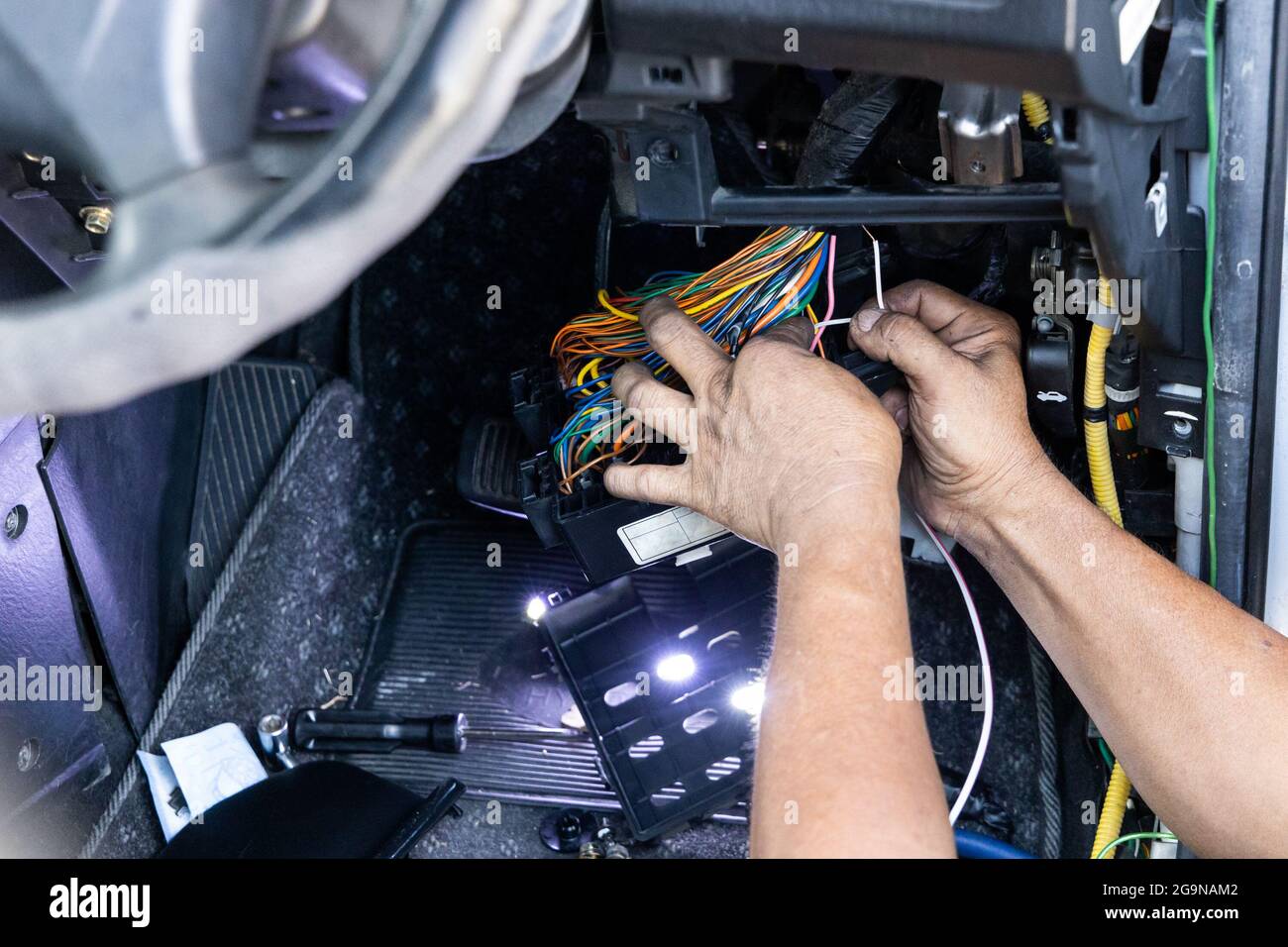 Auto technician diagnose and fixing wiring problem of car Stock Photo