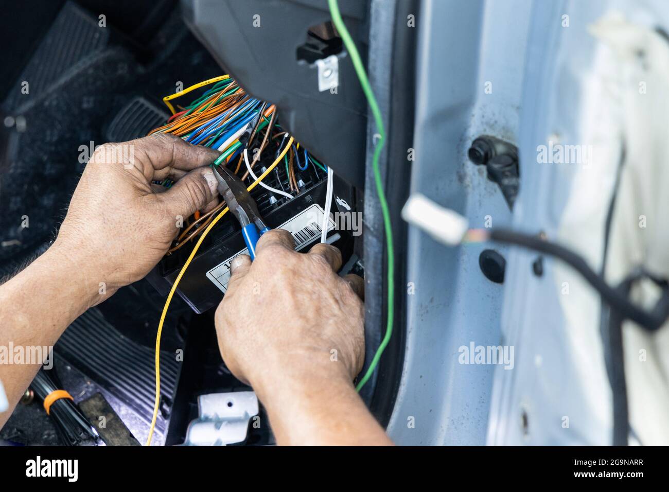Auto technician diagnose and fixing wiring problem of car Stock Photo