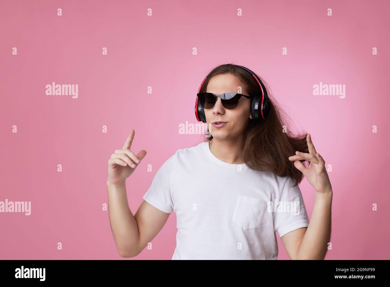 man in sunglasses listens to music with headphones and dances Stock Photo