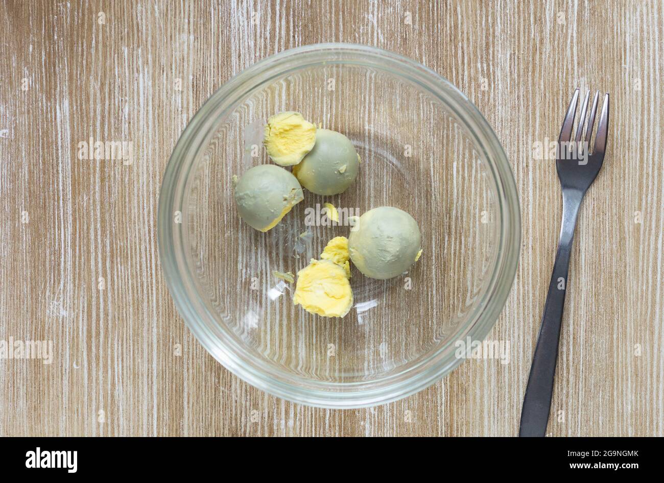 Top view of boiled yolks in glass bowl before crushing it by fork Stock Photo