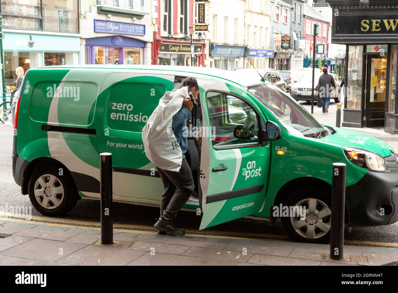 Young An Post or Irish Post employee postman with company branded van ...