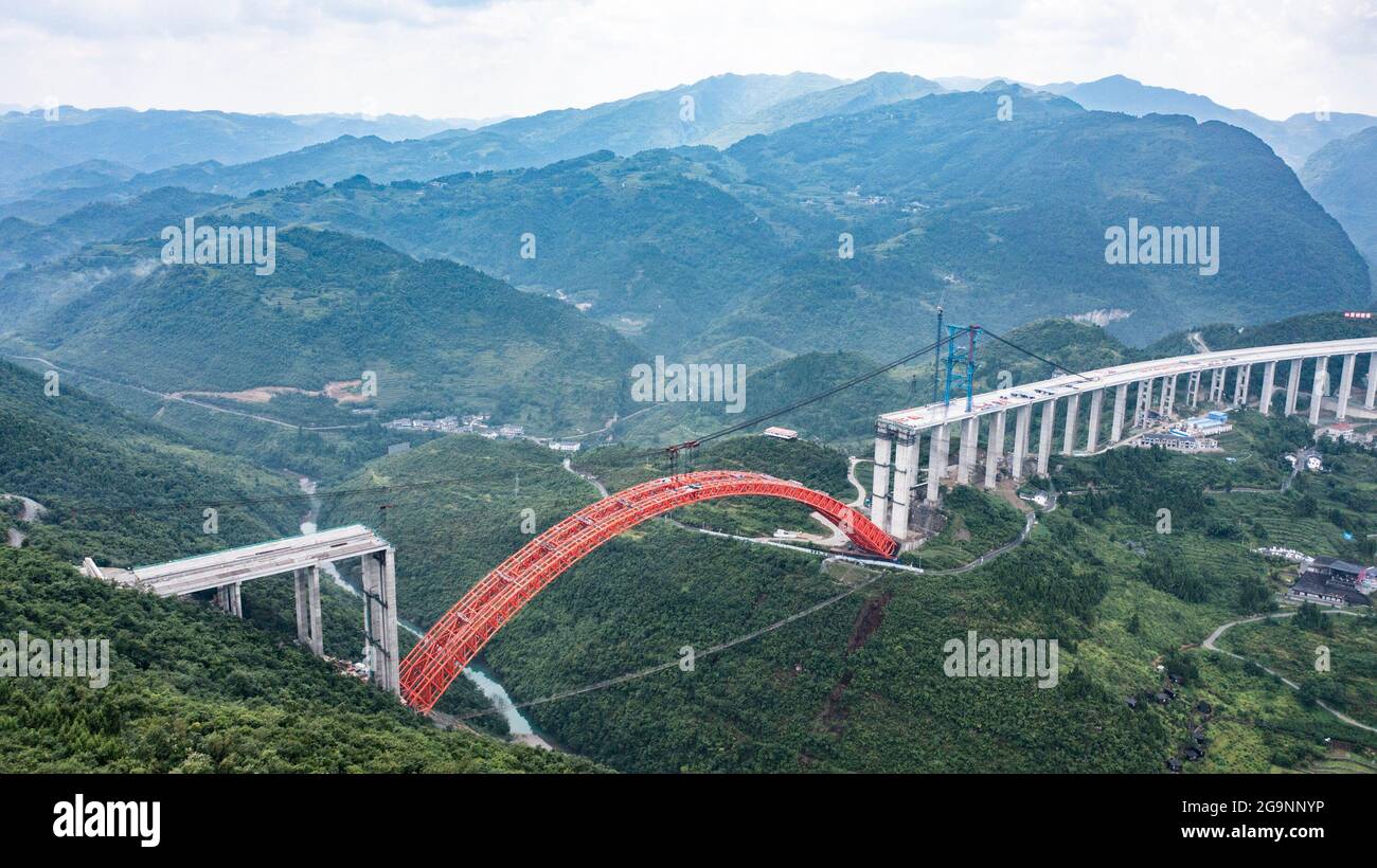 Zunyi. 27th July, 2021. Aerial photo taken on July 27, 2021 shows the construction site of the Dafaqu grand bridge of Renhuai-Zunyi expressway in southwest China's Guizhou Province. The main arch of Dafaqu grand bridge successfully closed on Tuesday. The bridge, with designed length of 1,427 meters and width of 33 meters, is one of the key projects along the expressway. Credit: Tao Liang/Xinhua/Alamy Live News Stock Photo