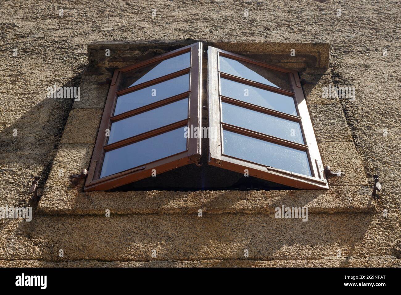Old wood frame windows set in a stone church wall hires stock