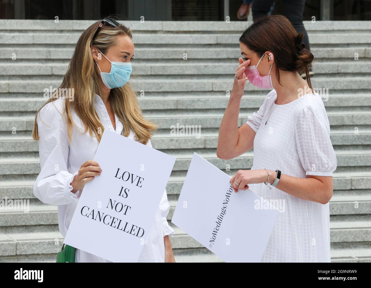 Dublin, Ireland. 27/07/2021 Brides to be, protest outside the Department of Health in Dublin, Ireland, over restricted guest numbers at weddings over Covid-19 restrictions. Pictured are (l to r) Orla O’Huadhaigh and Ali O'Mara as a group of brides-to-be outside the Department of Health on Baggot Street to present their health & safety guidelines in a bid to allow their weddings go ahead this year. The centrepiece of the 40 pages of guidelines is to seek to safely raise the guest limit for wedding receptions to 100 guests from August. Photograph: Sam Boal / RollingNews.ie Stock Photo