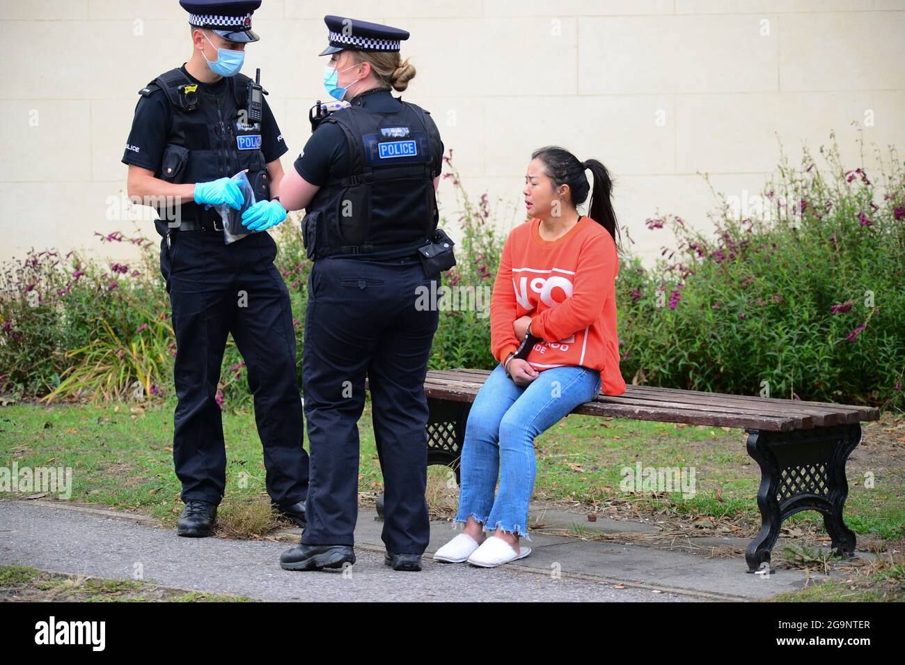 officers guard a handcuffed suspect Stock Photo Alamy