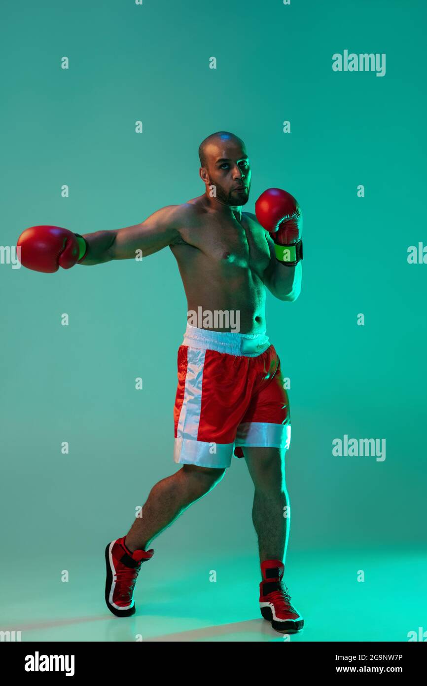 Vertical portrait of one professional male boxer training, exercising ...