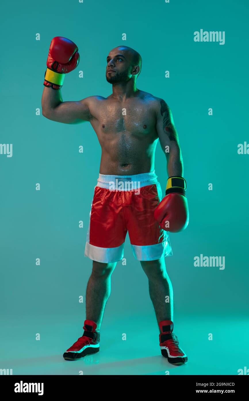 Vertical portrait of one professional male boxer standing isolated over ...