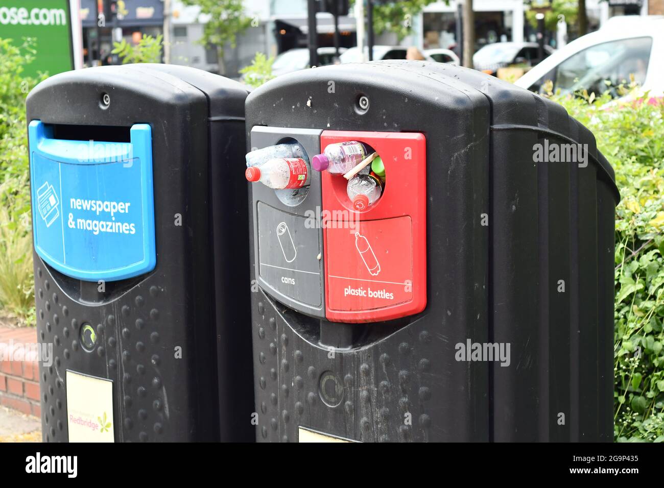Newspaper and magazines recycling bin and an overflowing cans and plastic bottle recycling bin Stock Photo