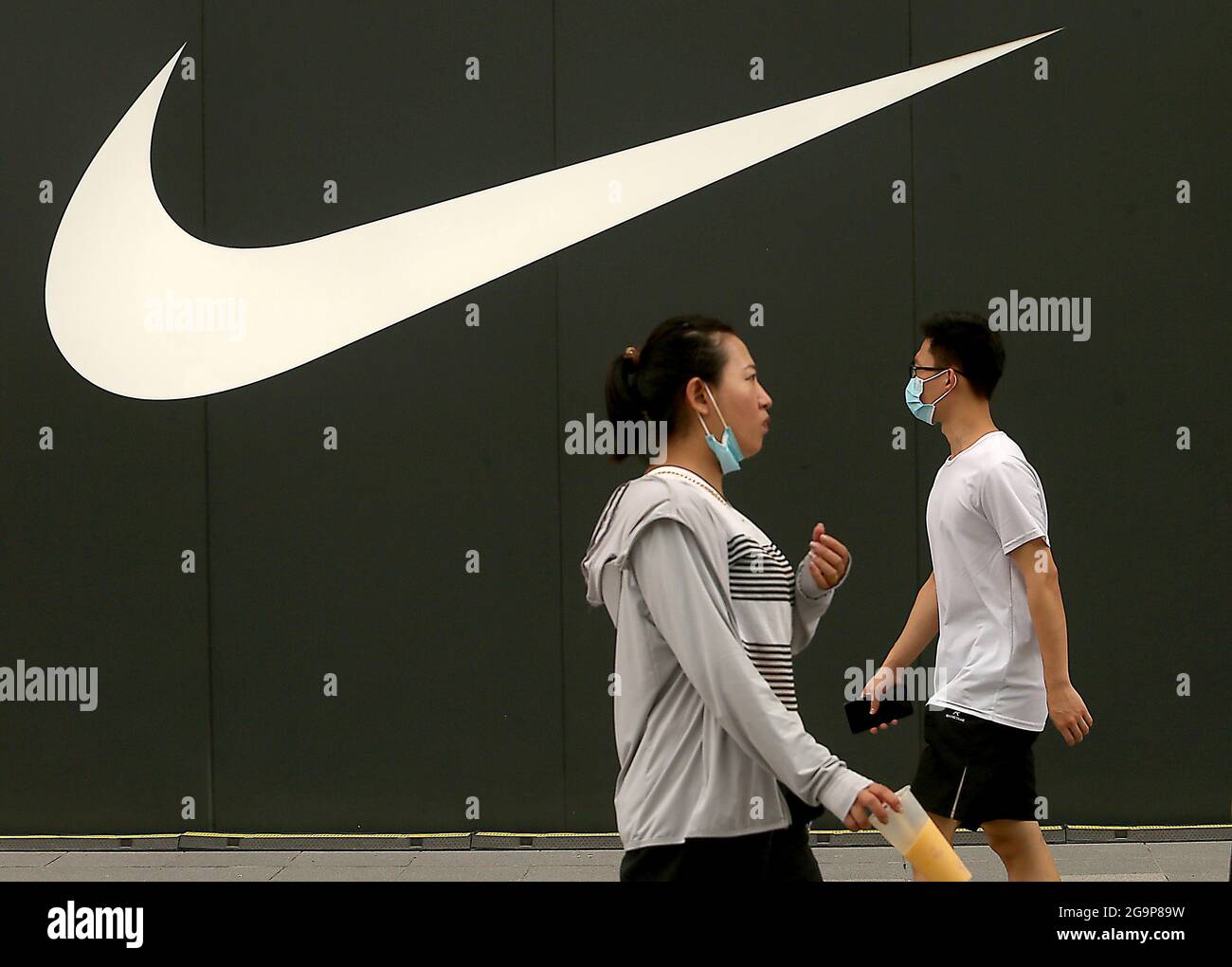 Beijing, China. 27th July, 2021. Chinese walk past a new Nike showroom in  downtown Beijing, on Tuesday, July 27, 2021. A Chinese company which makes  sneakers for Nike in China sent Xinjiang
