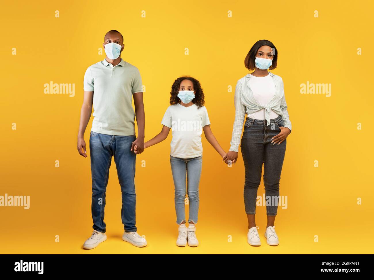 Young black parents and their child daughter wearing medical face masks ...