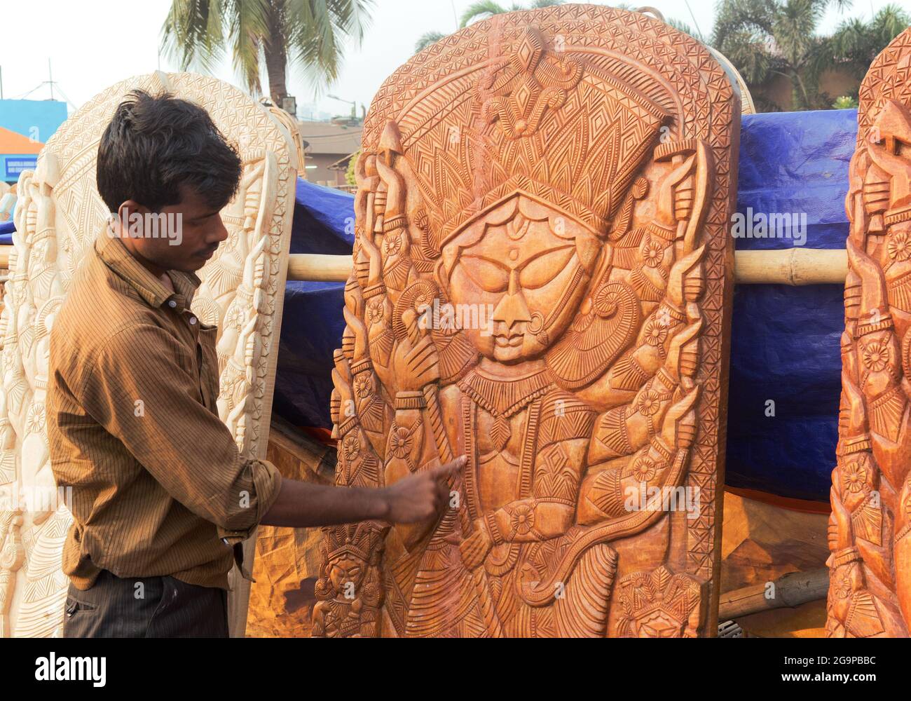 KOLKATA, WEST BENGAL , INDIA - NOVEMBER 23RD 2014 : Unidentified person polishing wood made Goddess Durga, handicrafts on display during the Handicraf Stock Photo