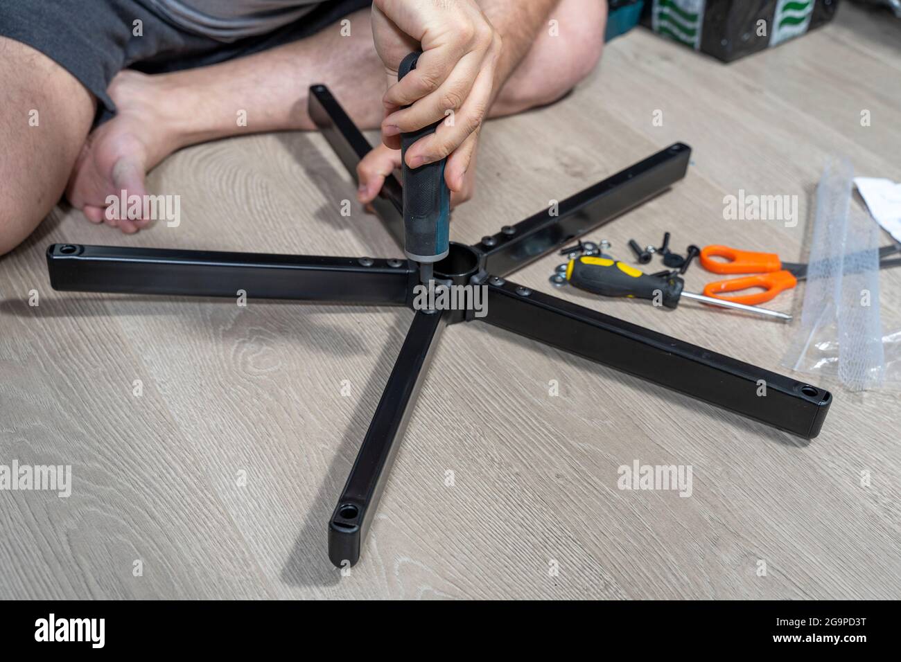 a man assembles a new chair at home. Stock Photo
