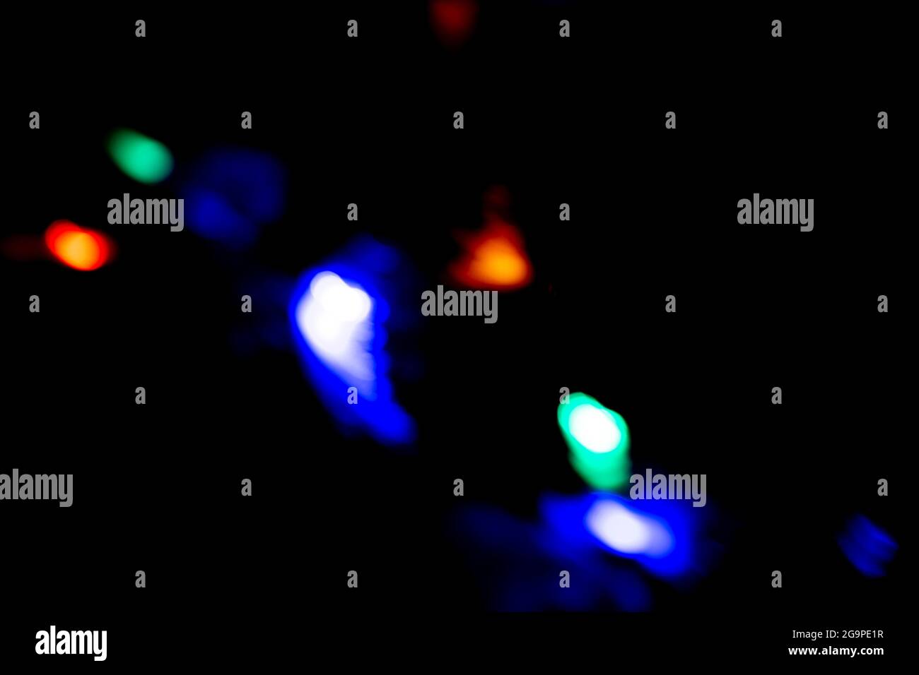 colored bokeh lights sparkling on black background Stock Photo