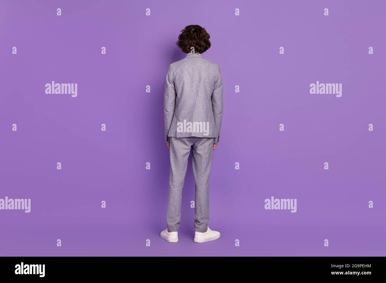 Rear back view photo of anonymous incognito pupil schoolboy guy wear grey suit isolated violet color background Stock Photo