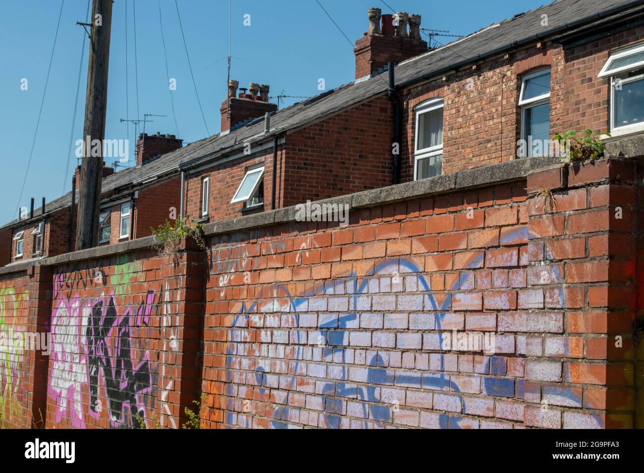 red brick terraced houses with grafitti on wall in manchester, uk, manchester houses, manchester terrace, terraced homes manchester, coronation street Stock Photo