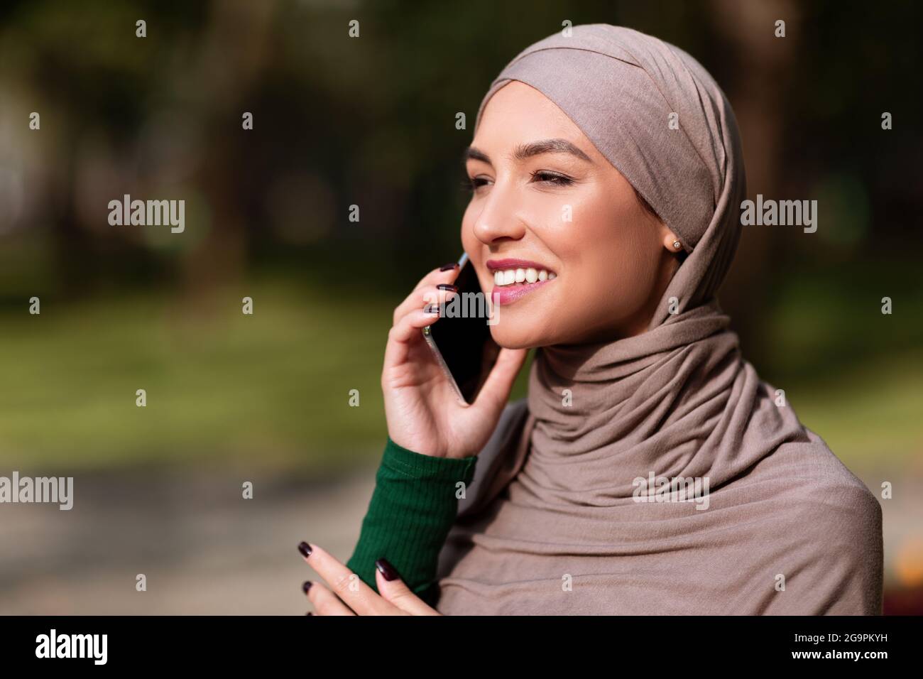 Happy Islamic Woman In Hijab Talking On Mobile Phone Outside Stock ...