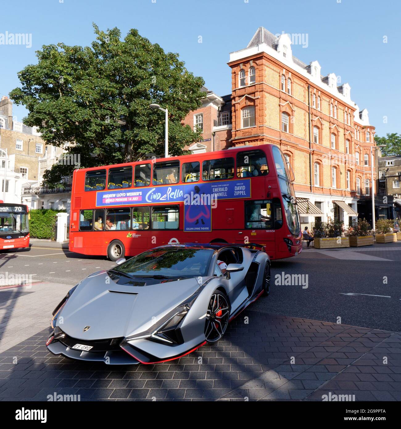 London, Greater London, England, July 17 2021: Sports car and bus at a crossroads by Exhibition Road in South Kensington. Stock Photo