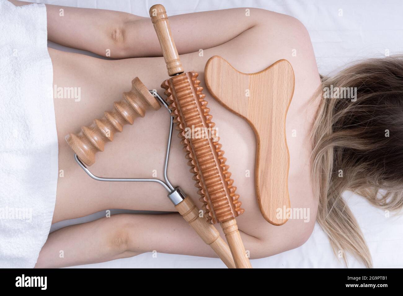 Madero therapy, anti-cellulite relaxing massage - wooden massage tools roller  spiked, rolling pin, plate lying on a woman's back, top view, close-up  Stock Photo - Alamy