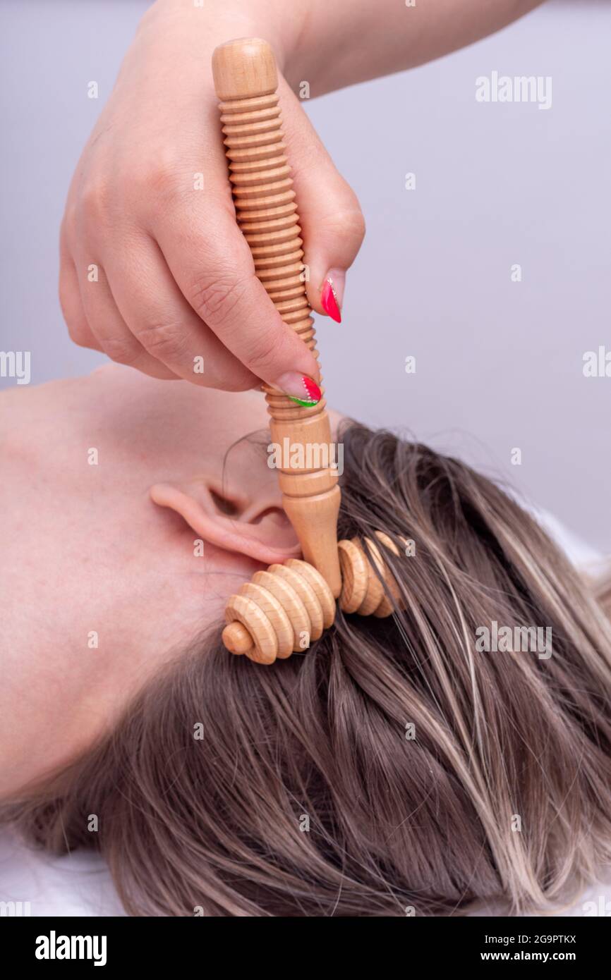 Massage the roots of the girl's hair using the wooden roller massager,  close-up. Massage hair roots so that hair grows healthy, lush. Beautiful  strong Stock Photo - Alamy