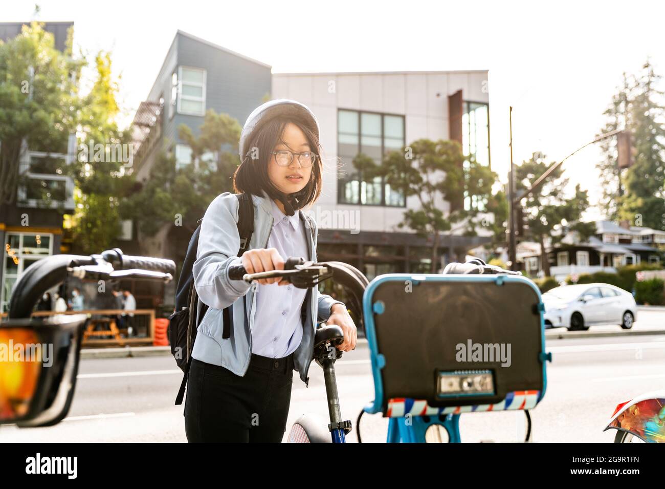 Young professional using bike share in urban setting Stock Photo