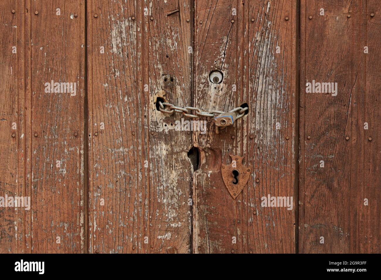 Antique wooden door with rusted hardware Stock Photo